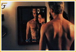Natalie lee en el espejo las inscripciones que Leonard se ha hecho en la piel.